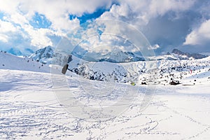 People kite siiking in a snowy slope with majestic mountain peaks in backgroud photo