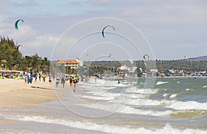 People and kites of wind surfers in a beach in Nam Tien, Vietnam