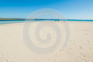 People in La Pelosa beach on sunny winter day