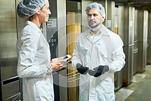 People in lab coats talking near elevators
