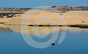 People on the lake with sand hills in Phan Thiet, Vietnam