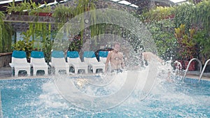 People laying in pool chairs jump to the pool