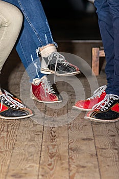 People legs with bowling shoes standing on old wooden floor