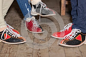 People legs with bowling shoes standing on old wooden floor
