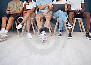 People, legs and sitting in waiting room networking for interview, social media or marketing team. Leg of group in wait