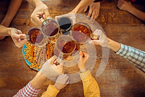 People, leisure, friendship and communication concept - happy friends drinking beer, talking and clinking glasses at bar