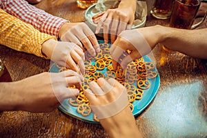 People, leisure, friendship and communication concept - happy friends drinking beer, talking and clinking glasses at bar