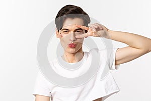 People, lgbtq community and lifestyle concept. Close-up of sassy and beautiful gay man with glitter on face, pucker lips