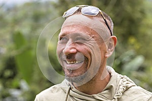 People and lifestyle concept. Happy middle-aged unshaven man with cheerful smile outdoor against green nature background, portrait