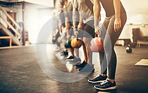 People lifting dumbbells together during a gym workout class