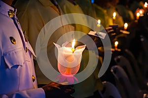 People hold candles light at night