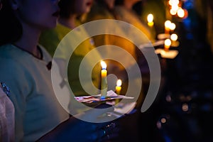 People hold candles light at night