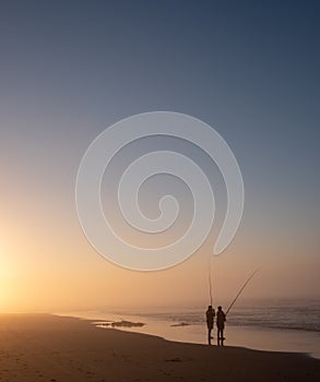 People line fishing at Morgan Bay beach at sunset, Wild Coast, Eastern Cape, South Africa.