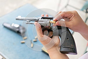 People load bullets into revolver gun