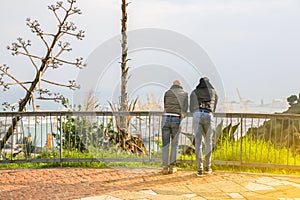 People looking at the Barcelona port from Montjuic castle. Harbour with ships in the city. Tourists enjoying the view