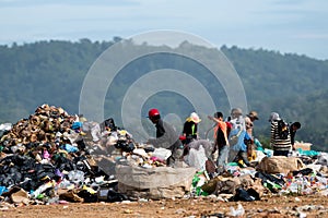 People looking through rubbish on landfill site