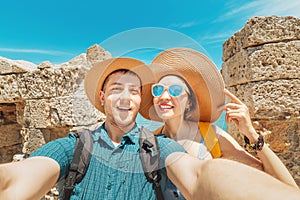 People in love hugging and taking selfie in old fortress with view to the sea resort. Couple travel and honeymoon trip