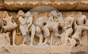 People in love scene in stone relief of ancient India. Khajuraho temple with sexual motif artworks, India.