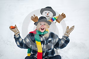People Love winter. Winter woman. Greeting snowman. Joyful girl Having Fun with snowman in Winter Park. People in snow.