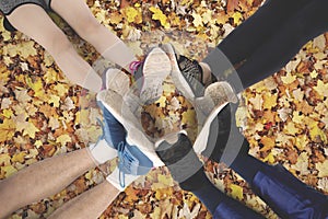 People make foot circle on autumn leaves