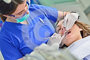 People, medicine, stomatology and health care concept - happy female dentist checking patient girl teeth