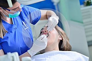 People, medicine, stomatology and health care concept - happy female dentist checking patient girl teeth