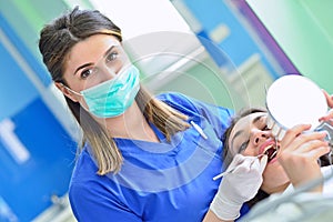 People, medicine, stomatology and health care concept - happy female dentist checking patient girl teeth