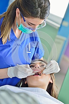 People, medicine, stomatology and health care concept - happy female dentist checking patient girl teeth