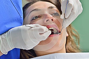 People, medicine, stomatology and health care concept - happy female dentist checking patient girl teeth