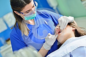 People, medicine, stomatology and health care concept - happy female dentist checking patient girl teeth