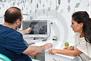 people, medicine, stomatology and health care concept - happy male dentist showing work plan to woman patient at dental