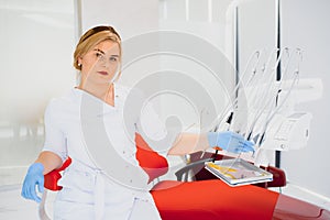 People, medicine, stomatology and healthcare concept - happy young female dentist with tools over medical office background