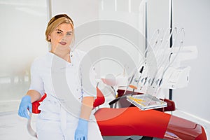 People, medicine, stomatology and healthcare concept - happy young female dentist with tools over medical office background