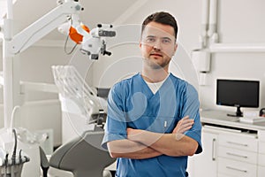 People, medicine, stomatology and healthcare concept - happy young male dentist with tools over medical office background