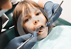 People, medicine, stomatology, technology and health care concept. Male dentist working with little girl in clinic.