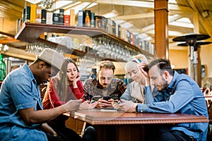 People Meeting Communication Technology Digital Tablet Concept. Group of five multiethnical students sitting in a cafe