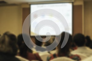 People in meeting or conference room blurred for background