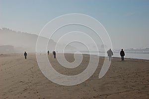 People on misty ocean beach