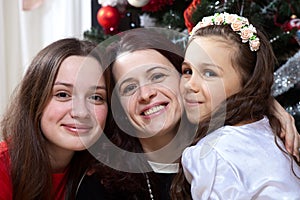 People, motherhood, family, christmas and adoption concept - happy mother and daughter hugging at home