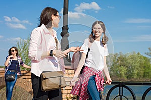 People, motherhood, family, summer. - Happy mother and daughter talking outdoors.