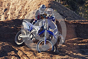 People, motorbike and outdoor by rocks on dirt path with adventure, transportation and extreme sports. Racer, rider and