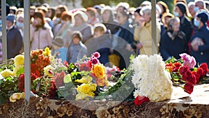 people and mourning concept - woman with white lily flowers and coffin at funeral in church