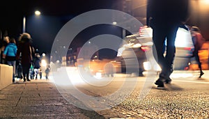 People moving in the street at night. Motion blur effect . Crowded public place with people passing.