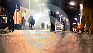 People moving in the street at night. Motion blur effect . Crowded public place with people passing.