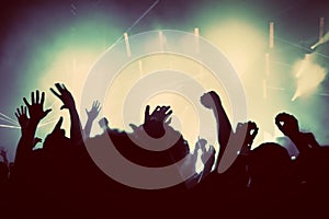La gente con las manos arriba para divertirse en un concierto de la música, la discoteca la fiesta.