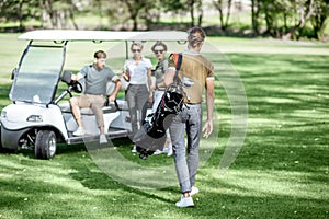 People near the golf car on the playing course