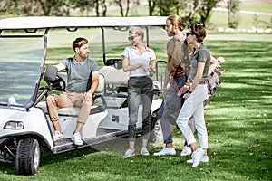 People near the golf car on the playing course