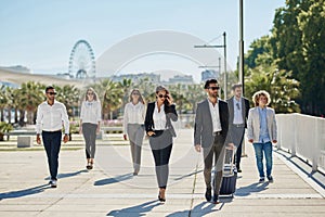 People in official clothes walking together on business trip