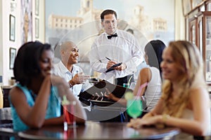 People ordering meal to waiter in restaurant photo