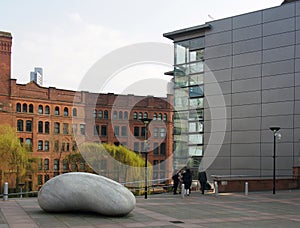 People outside the bridgewater hall concert venue in manchester city centre with the ishinki touchstone sculpture outside the